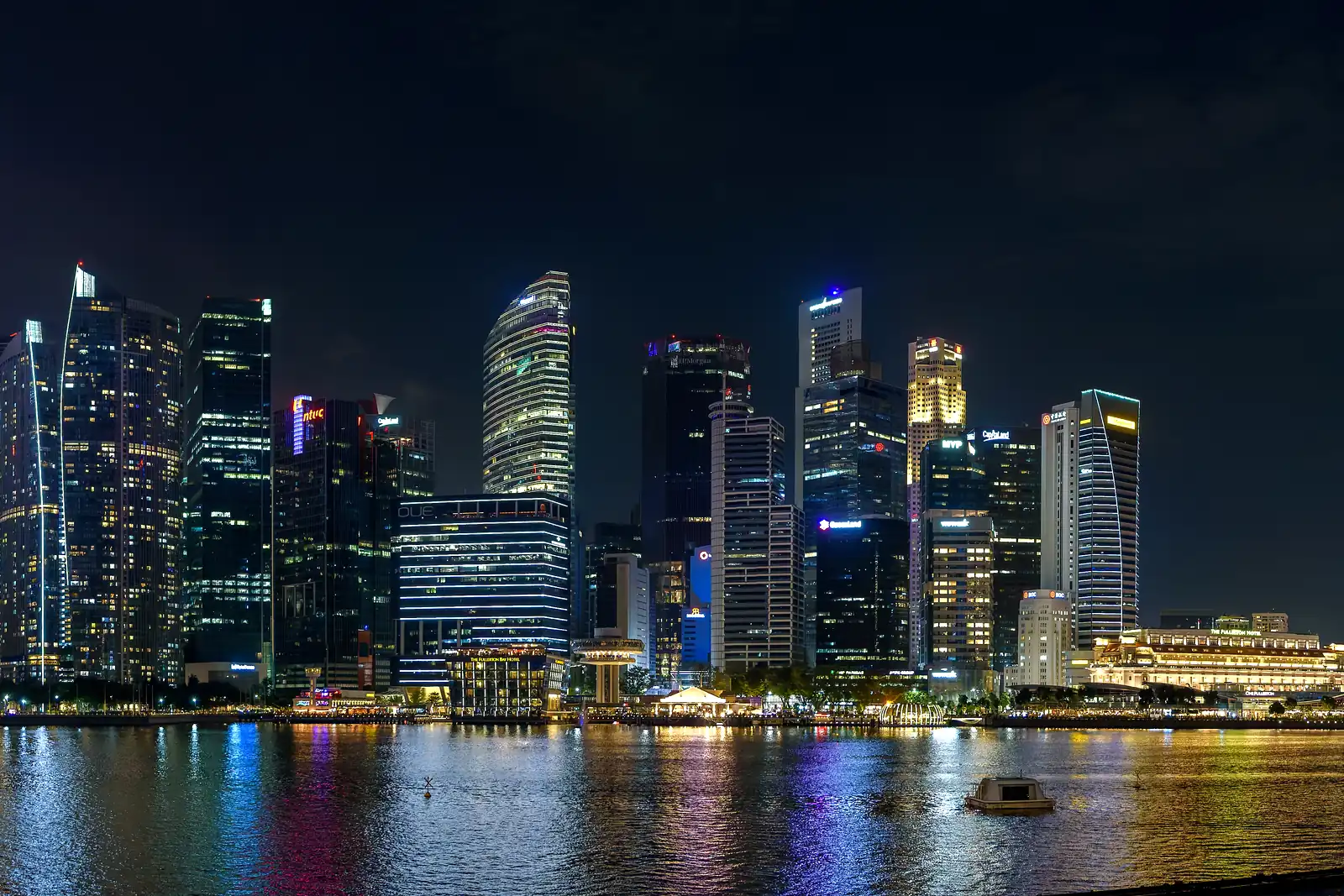 Singapore CBD skyline lit up at blue hour across Marina Bay